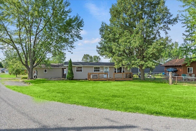 ranch-style home featuring a deck and a front lawn