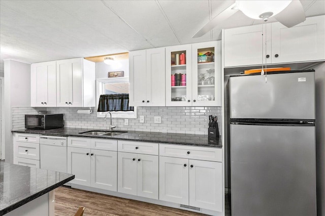 kitchen featuring dishwasher, stainless steel refrigerator, and white cabinets