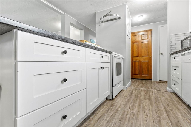 kitchen with white cabinetry, light wood-type flooring, and decorative backsplash