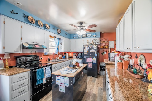 kitchen with ceiling fan, a sink, black appliances, light wood-style floors, and under cabinet range hood