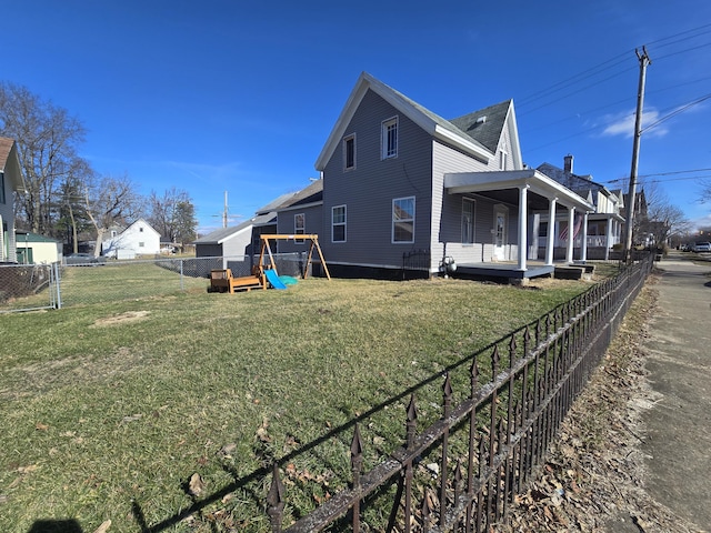 view of side of home with a yard, a playground, and a porch