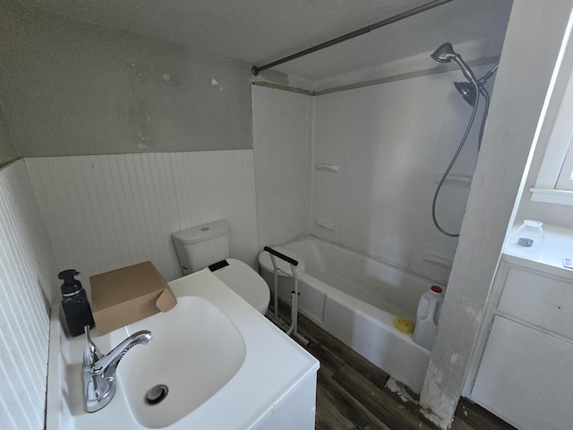 full bathroom with toilet, bathing tub / shower combination, sink, and hardwood / wood-style floors