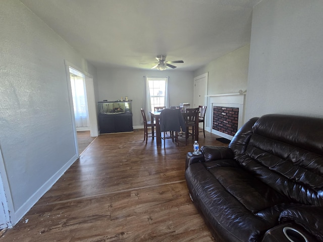 living room with dark wood-type flooring and ceiling fan