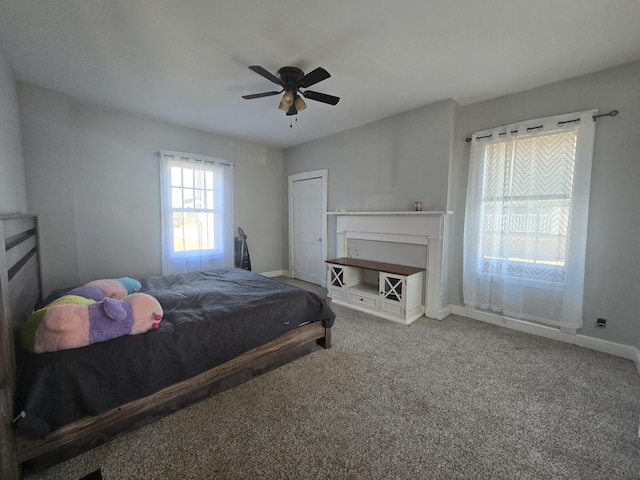 bedroom with a fireplace, ceiling fan, and carpet