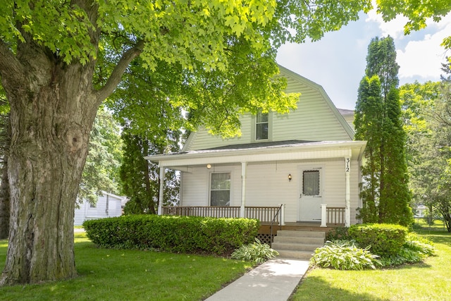 312 E Buckeye St, Belle Center, OH 43310 - dutch colonial featuring a porch, a front lawn, and a gambrel roof