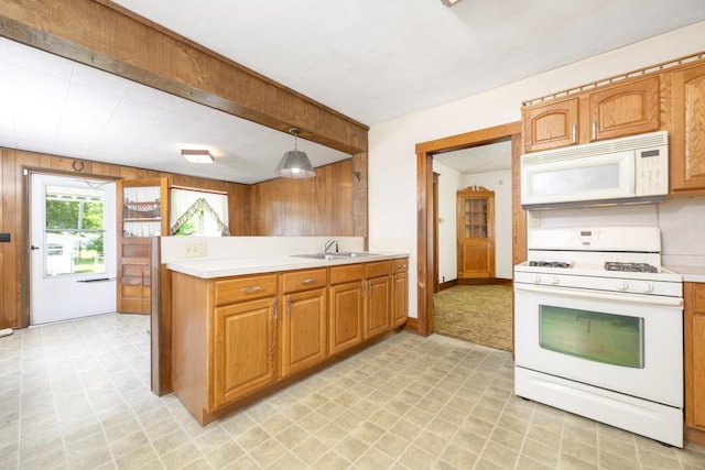 312 E Buckeye St, Belle Center, OH 43310 - kitchen featuring white appliances, wood walls, light countertops, a sink, and a peninsula