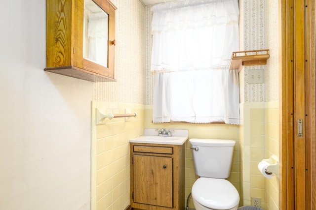 312 E Buckeye St, Belle Center, OH 43310 - half bath with wallpapered walls, a wainscoted wall, toilet, tile walls, and vanity