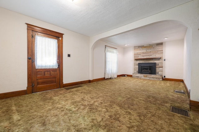 312 E Buckeye St, Belle Center, OH 43310 - unfurnished living room featuring carpet flooring, arched walkways, a fireplace, and baseboards