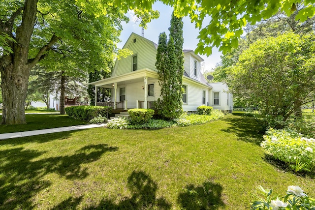 312 E Buckeye St, Belle Center, OH 43310 - view of front facade with covered porch, a front yard, and a gambrel roof