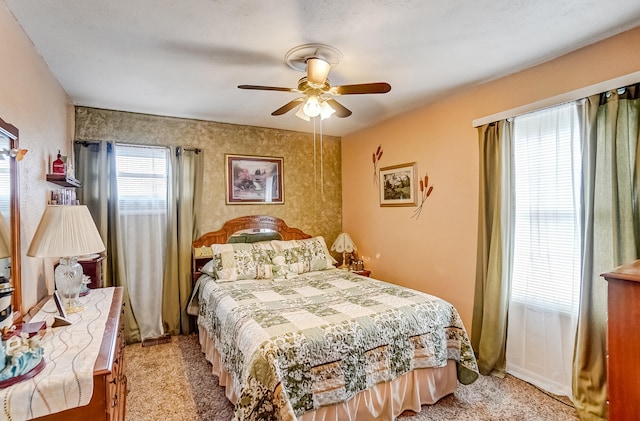 bedroom featuring light carpet and a ceiling fan