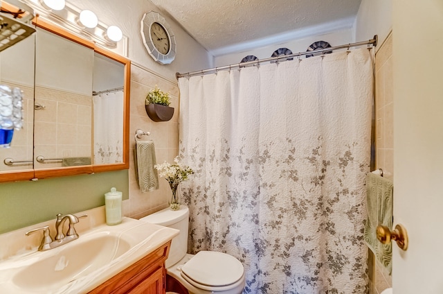 full bathroom with a textured ceiling, curtained shower, vanity, and toilet