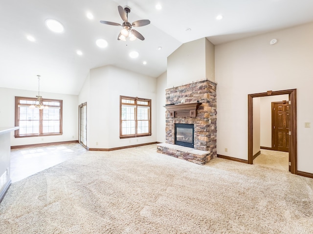 unfurnished living room with high vaulted ceiling, ceiling fan with notable chandelier, a fireplace, baseboards, and carpet flooring