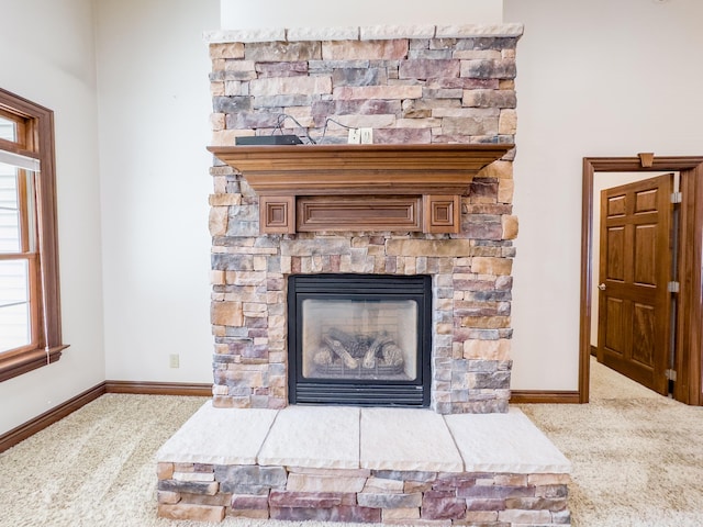 details featuring carpet, baseboards, and a stone fireplace