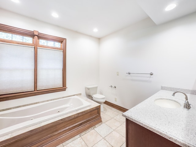 full bath with tile patterned floors, vanity, a whirlpool tub, baseboards, and toilet
