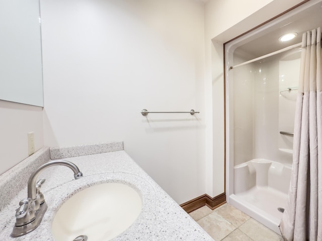 bathroom with tile patterned flooring, baseboards, vanity, and curtained shower