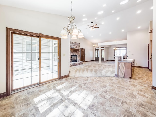 kitchen featuring a fireplace, open floor plan, pendant lighting, and baseboards