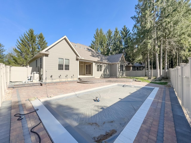 rear view of house featuring a fenced backyard and a patio area