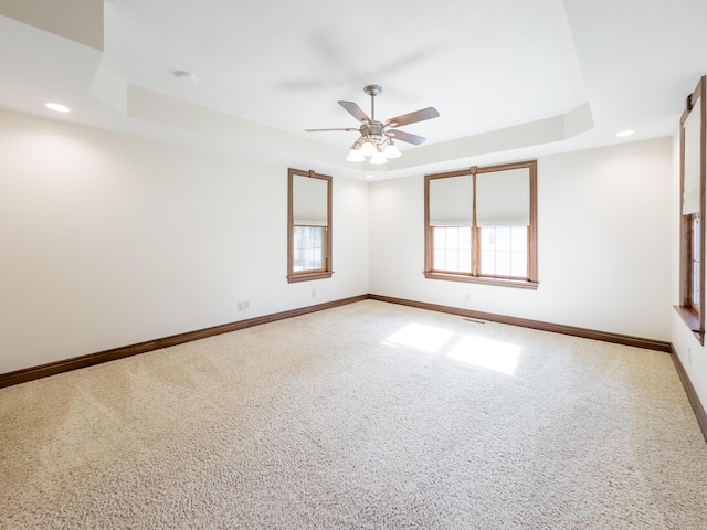 carpeted spare room with recessed lighting, ceiling fan, baseboards, and a raised ceiling
