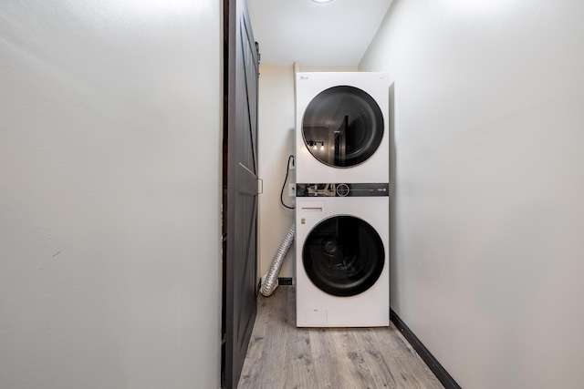 11181 Elm St, Lakeview, OH 43331 - laundry area with stacked washer and clothes dryer, light wood-type flooring, and baseboards