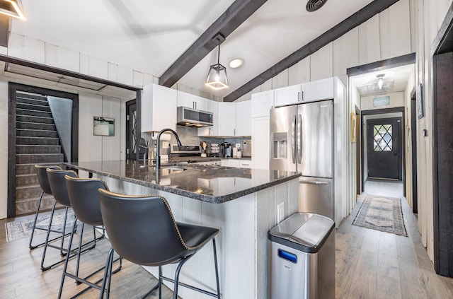 11181 Elm St, Lakeview, OH 43331 - kitchen featuring appliances with stainless steel finishes, a sink, light wood-style flooring, and a breakfast bar area