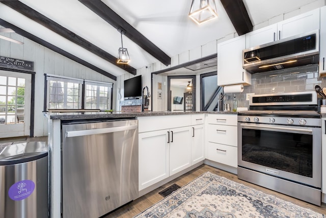 11181 Elm St, Lakeview, OH 43331 - kitchen with stainless steel appliances, tasteful backsplash, white cabinetry, pendant lighting, and light wood-style flooring