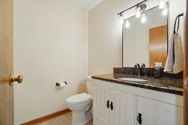 bathroom featuring tile patterned flooring, baseboards, toilet, and vanity