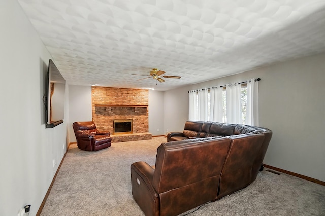 carpeted living area featuring baseboards, a ceiling fan, and a brick fireplace