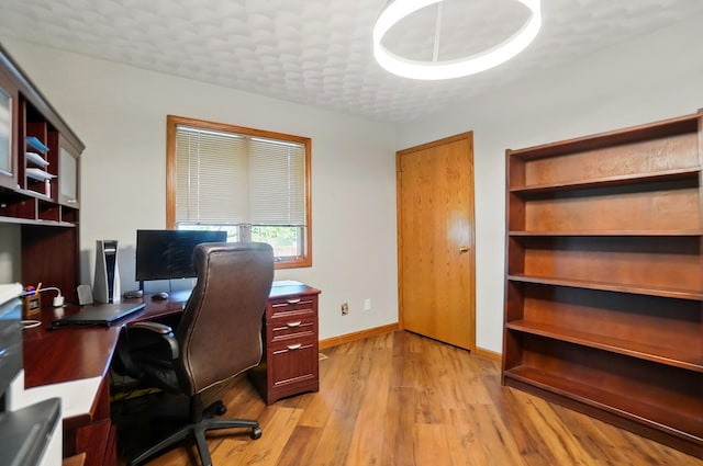 office space featuring baseboards and light wood-style flooring