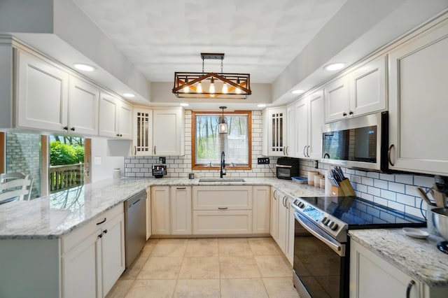 kitchen with a sink, decorative backsplash, stainless steel appliances, and a healthy amount of sunlight