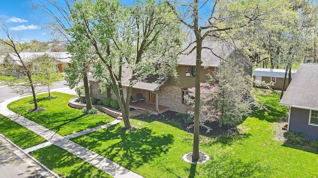 exterior space featuring brick siding, a front lawn, and roof with shingles