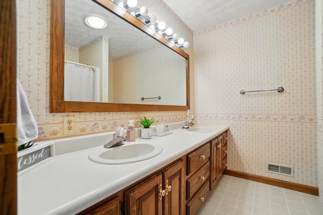 bathroom featuring a sink, wallpapered walls, double vanity, and visible vents