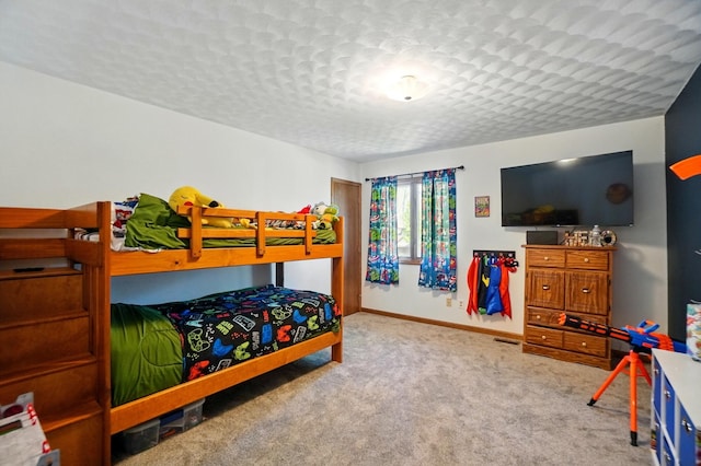 bedroom with a textured ceiling, baseboards, visible vents, and carpet
