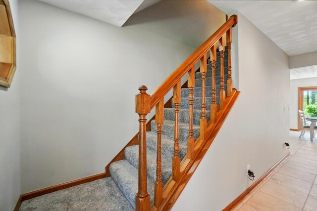 stairway featuring baseboards and tile patterned flooring