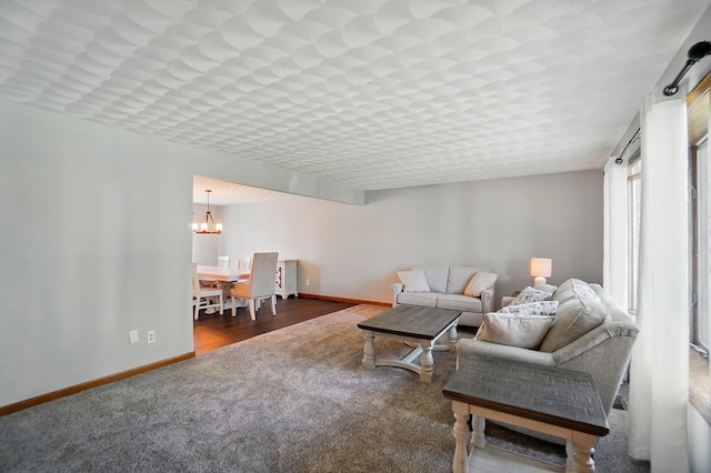 living room with baseboards, carpet, and a chandelier