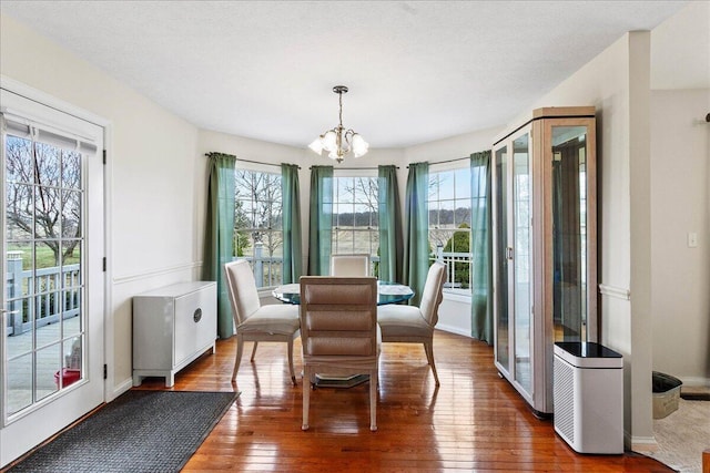 dining room with dark hardwood / wood-style flooring and a chandelier