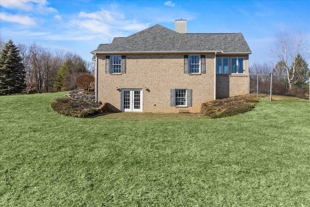 view of side of property featuring french doors and a lawn