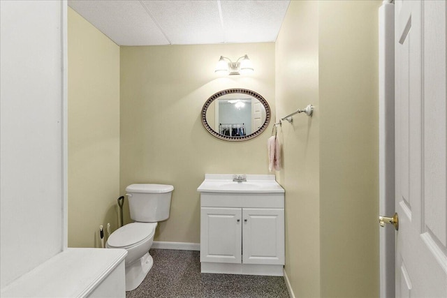 bathroom with vanity, a paneled ceiling, and toilet