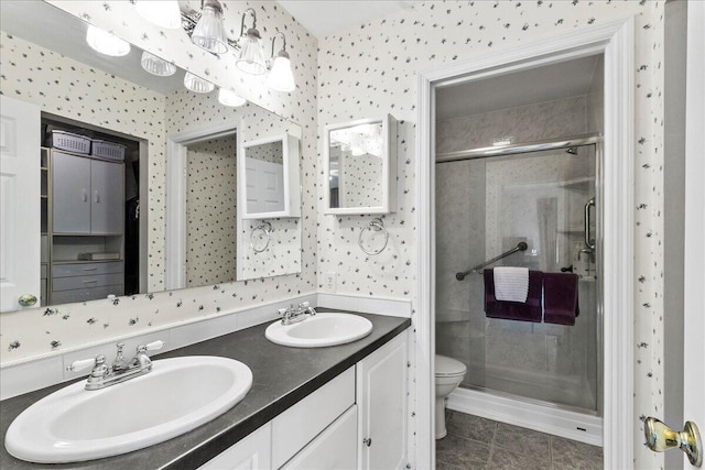 bathroom featuring tile patterned flooring, toilet, vanity, and walk in shower