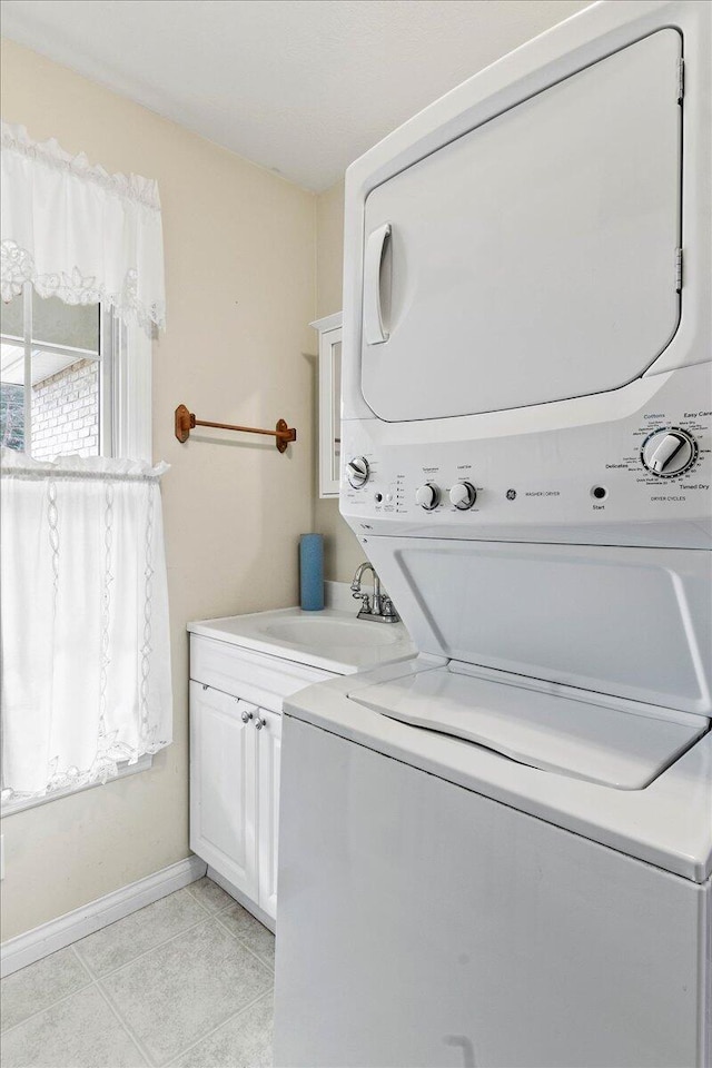 clothes washing area featuring stacked washer / drying machine, sink, cabinets, and light tile patterned flooring