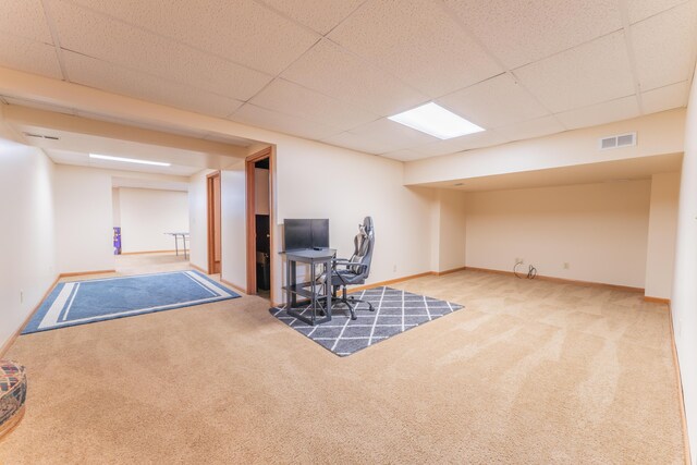 finished basement with baseboards, a paneled ceiling, visible vents, and carpet