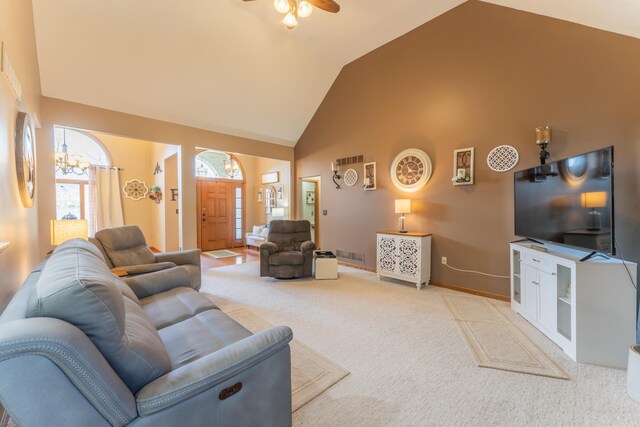 living room featuring carpet flooring, baseboards, visible vents, ceiling fan with notable chandelier, and high vaulted ceiling