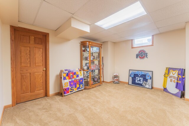 game room with carpet floors, a paneled ceiling, and baseboards