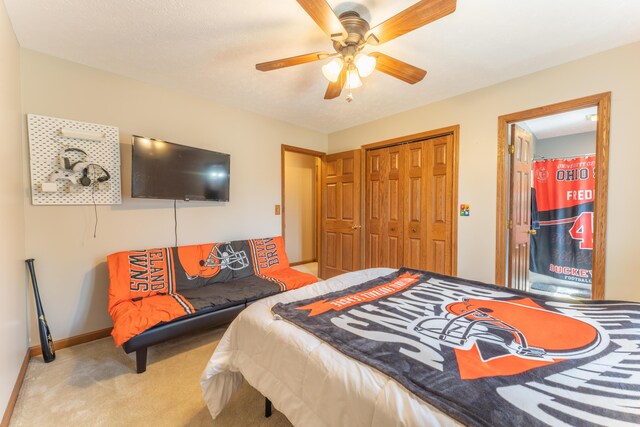 carpeted bedroom featuring a closet, a ceiling fan, and baseboards