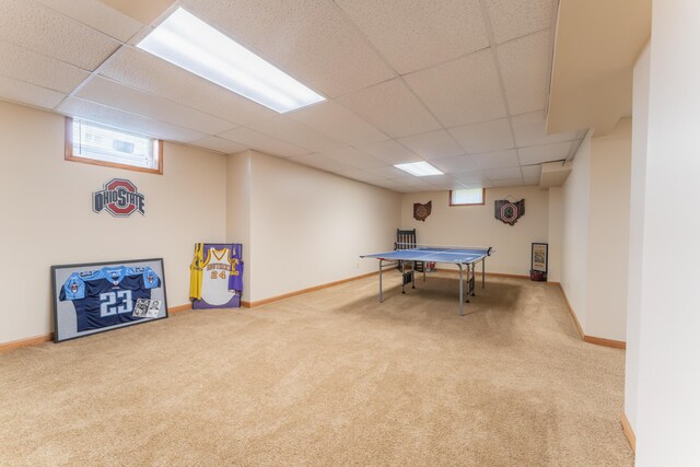 recreation room with carpet flooring, baseboards, and a drop ceiling