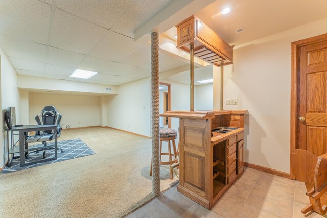 office area featuring baseboards, a dry bar, and light carpet