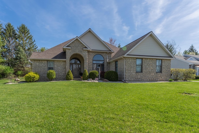 single story home with stone siding, a front lawn, and roof with shingles