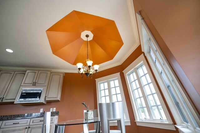 429 Braytonburne Dr, Springfield, OH 45503 - kitchen featuring a chandelier, decorative light fixtures, stainless steel microwave, dark countertops, and ornamental molding