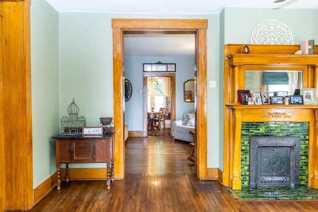 corridor featuring baseboards, visible vents, and hardwood / wood-style floors