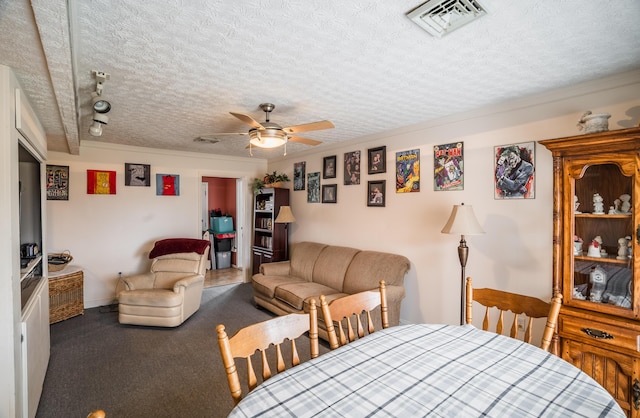 interior space featuring a textured ceiling, carpet flooring, visible vents, and a ceiling fan