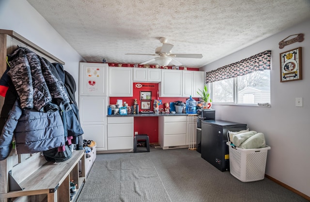 interior space featuring a textured ceiling, baseboards, a ceiling fan, and light colored carpet